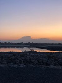 Rocks on sea against sky during sunset