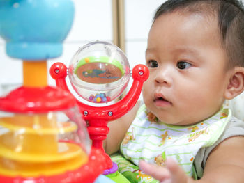 Asian little baby playing with colorful toys at home