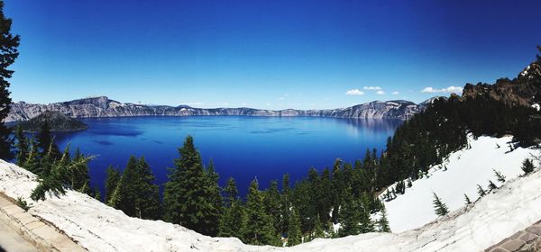 Scenic view of lake and mountains against blue sky