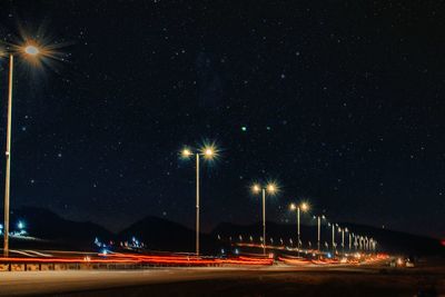 Light trails on street against sky at night