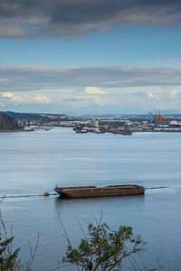 Clouds partially cover mount rainier which towers over the port of tacoma.