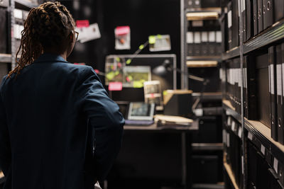 Rear view of man standing in library