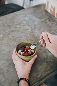 Cropped hand eating sweet food on table