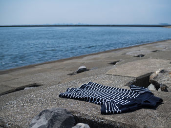 Close-up of deck chairs on beach against sky