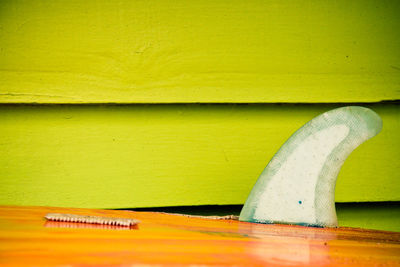 Close-up of wooden table against yellow wall