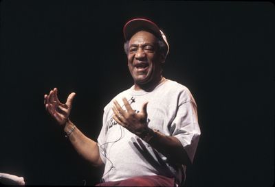 Portrait of smiling man standing against black background