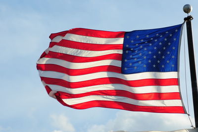 Low angle view of flag flags against sky