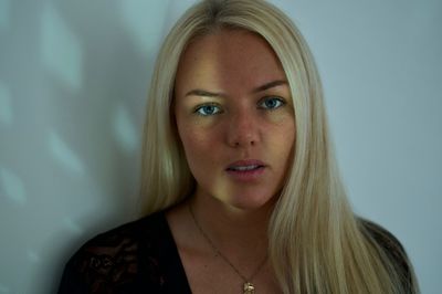 Close-up portrait of young woman against wall