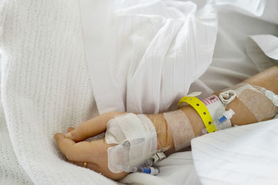 Midsection of patient wearing iv drip in hospital