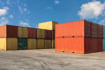 Stack of multi colored cargo containers at harbor against sky