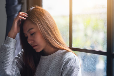 A sad and stressed young asian woman sitting alone in the room