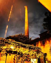 Low angle view of illuminated building against cloudy sky