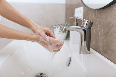 Cropped image of woman washing hands