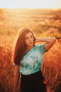 Beautiful young woman standing on field