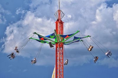 Low angle view of chain swing ride against sky