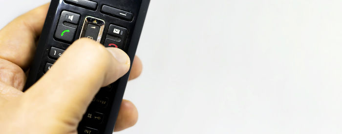 Close-up of hand holding smart phone over white background