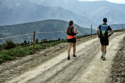 Rear view of men walking on road