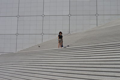 Full length of woman standing on staircase