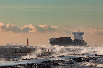 Merchant ship entering the port for unloading, storm at sea