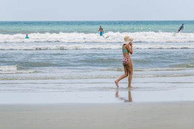 Bikini woman walking on beach