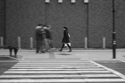 People walking on zebra crossing in city