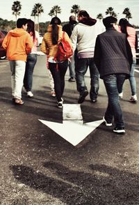 Rear view of people standing on road