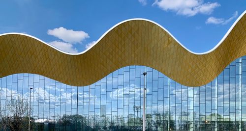 Low angle view of modern building against blue sky