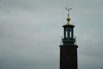 Low angle view of lighthouse by building against sky