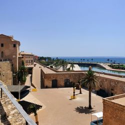 Buildings in city against clear blue sky