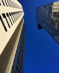 Low angle view of modern buildings against clear blue sky