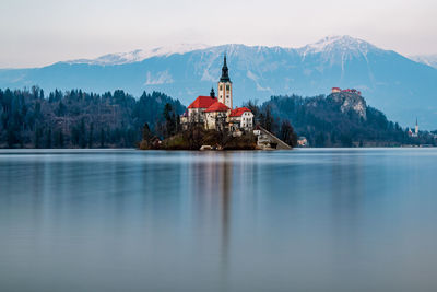 Scenic view of lake by building against sky