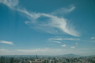 Aerial view of buildings in city against sky