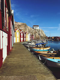 Small boats at jetty. bright sun clear sky.  colorful boat houses. sweden west coast smögen