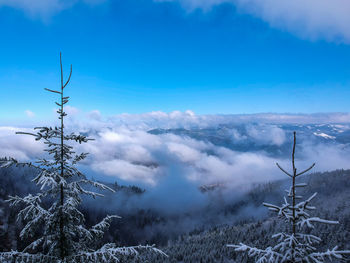 Scenic view of snow covered mountains against blue sky