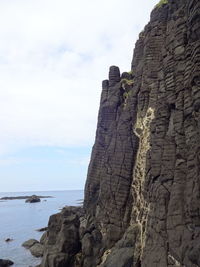 Rock formation on beach against sky