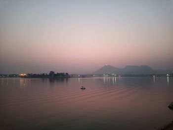Scenic view of lake against clear sky during sunset