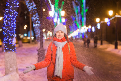 Portrait of smiling woman standing in snow