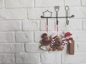 Close-up of gingerbread cookies hanging against white wall