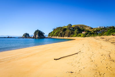 Scenic view of beach against clear blue sky