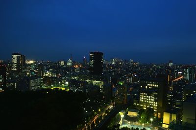 Illuminated cityscape against sky at night