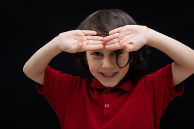 Portrait of smiling boy against black background