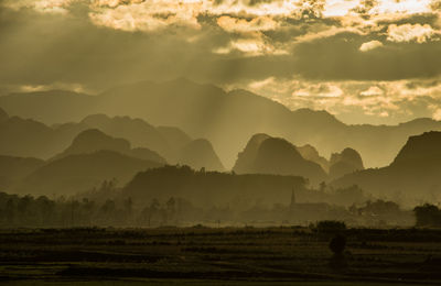 Scenic view of land and mountains against sky