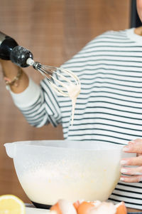 Woman kneading the dough while cooking apple pie in the modern kitchen