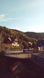 Houses by trees and buildings against sky