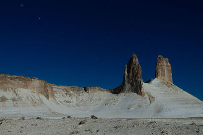 Low angle view of rock formations against clear blue sky