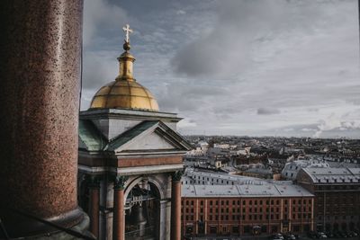 Buildings in city against cloudy sky