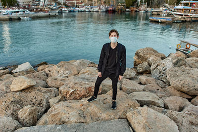 Man standing on rock by river