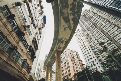 Low angle view of buildings and bridge against sky in city