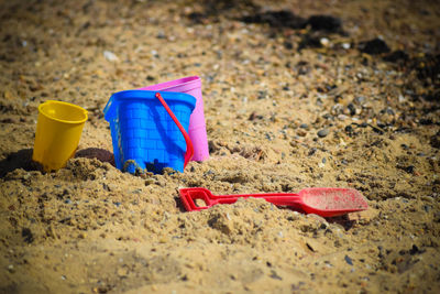 Close-up of colourful buckets and spade on sand at beach with copy space 