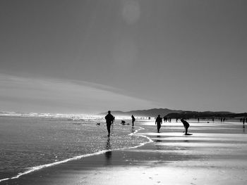 People on beach against sky